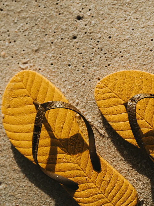 Gelber Slipper mit schwarzem Riemen